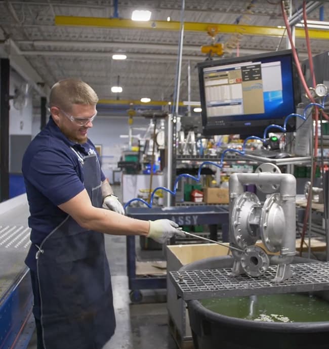 Warren Rupp team member spraying pump